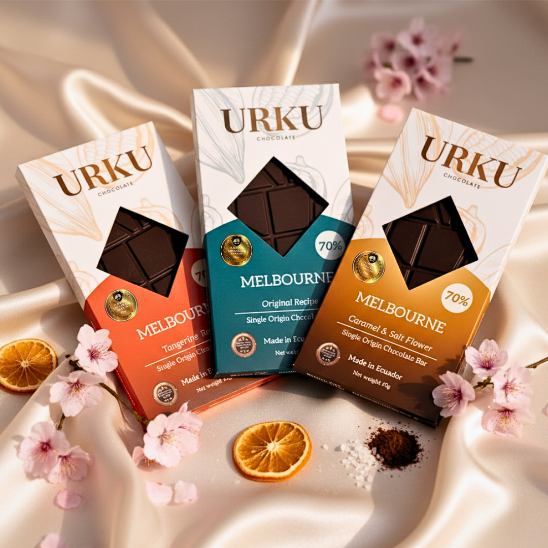 Three URKU chocolate bars: URKU Melbourne Pure 70% Gold Medal Dark Chocolate Bar, URKU Limited Edition Caramel & Salt Flower Chocolate Bar with flowers and oranges.